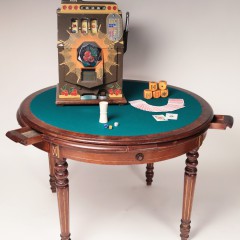 Victorian walnut felt top poker table with six drawers pictured with a vintage slot machine and carved bone dice cup