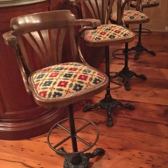 Set of Four Swivel Bar Stools, walnut frame with upholstered seats on cast iron bases.