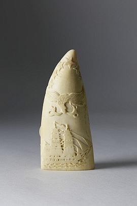 Whaleman Carved and Scrimshawed Sperm Whale Tooth, circa 1860, bas relief carved fully rigged bark on ocean with six stars and spread winged eagle with banner above. The reverse scrimshawed with monument of six American flags. Height 5 ¼ in. Provenance: Eldred’s