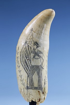 Whaler Scrimshawed Whale Tooth of Jack Tar, circa 1860, a folksy portrait of Jack Tar standing holding an American flag in one hand and a sabre in the other, the reverse with a 5-point star.