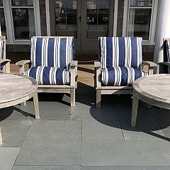 Four Gloster Teak Armchairs with Blue and White Striped Cushions and Two Large Round Cocktail Tables