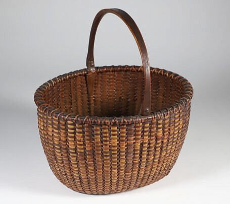 Fine Mid 19th Century Open Oval Swing Handle Nantucket Basket with Carved Wood Ears extending to the base plate